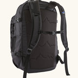 Back of the Patagonia refugio day pack 32 litre backpack in black showing the chest strap closed.
