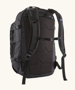Back of the Patagonia refugio day pack 32 litre backpack in black showing the chest strap closed.