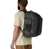 Man wearing the Patagonia refugio day pack 32 litre backpack in black. 