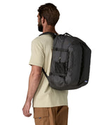 Man wearing the Patagonia refugio day pack 32 litre backpack in black. 