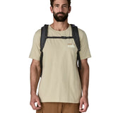 Man wearing the Patagonia refugio day pack 32 litre backpack in black on his back showing the chest back closed at the front. 