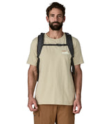 Man wearing the Patagonia refugio day pack 32 litre backpack in black on his back showing the chest back closed at the front. 