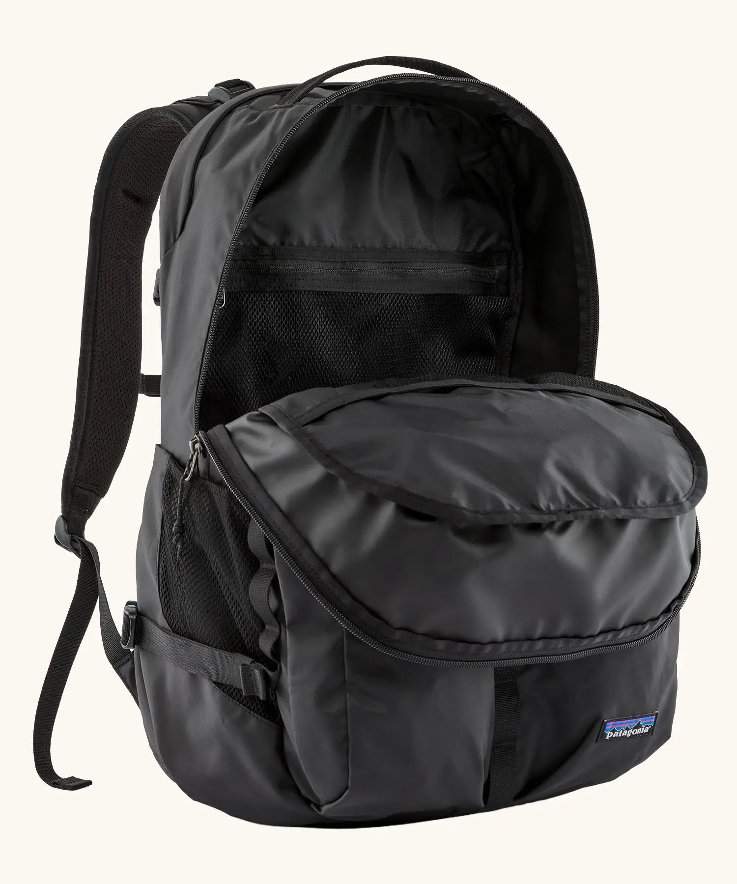 Patagonia refugio day pack 32 litre backpack in black shown with one of the compartments at the front open. 