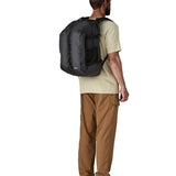 Man wearing the Patagonia refugio day pack 32 litre backpack in black on his back. 