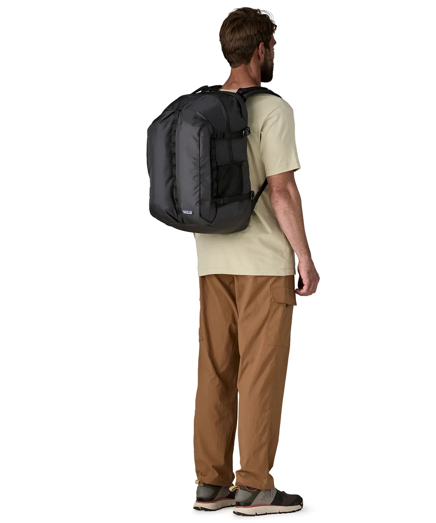 Man wearing the Patagonia refugio day pack 32 litre backpack in black on his back. 