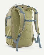 Back of the Patagonia refugio 32L daypack in weathered stone light green and blue trim. Padded straps and quick release buckle chest strap.