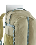 Laptop placed in the pocket at the back of the Patagonia refugio 32L day pack backpack in weathered stone light green and blue trim.