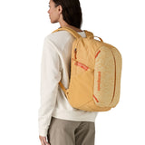 Patagonia yellow 26L day refugio backpack with a buttercup design worn by an adult