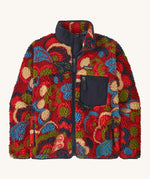 Patagonia womens retro-x jacket. A thick red fleece in red with different colour shapes all over. Features a navy full length zip, chest pocket and a logo patch stitched on the left chest.