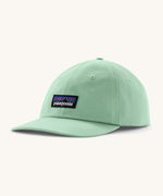 Patagonia adult trad cap in light green with logo on the front on a cream background.
