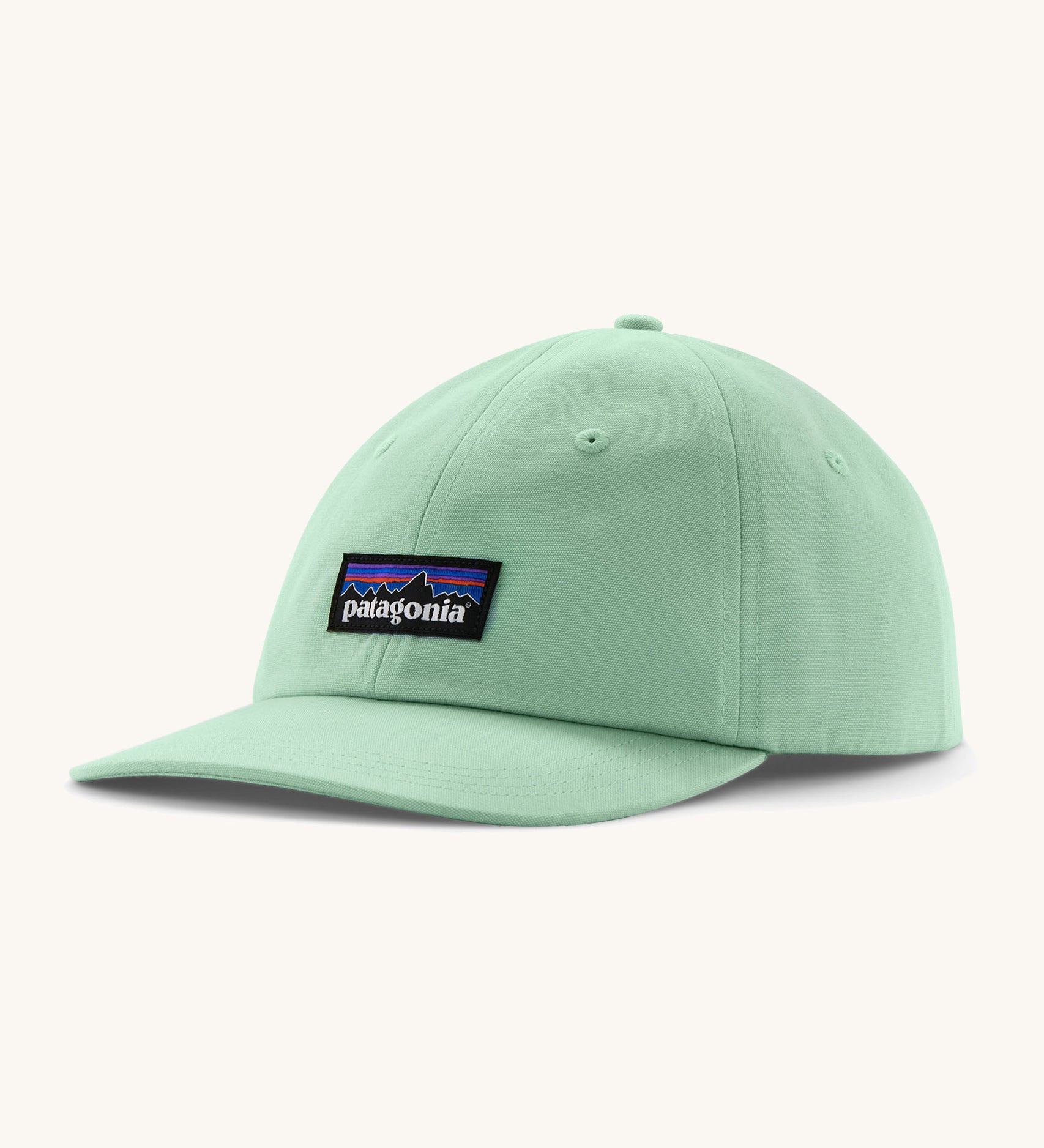 Patagonia adult trad cap in light green with logo on the front on a cream background.