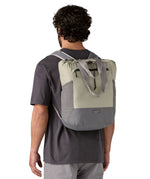 Patagonia Terravia tote bag in river rock green worn by a adult on the back showing the carrying handle details and side pockets for holding bottles
