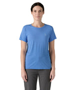 Patagonia women's short sleeve top in light blue beach outline and logo design worn by a woman