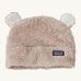 Patagonia little kids friends hat. A light grey furry beanie to keep the head warm which features white bear-like ears on the top of the beanie. Features the logo patch stitched on the front side of the hat.