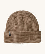 Patagonia adult snow drifter beanie in a pale khaki colour. A ribbed knitted style beanie with the logo branding on the side of the turn up brim.