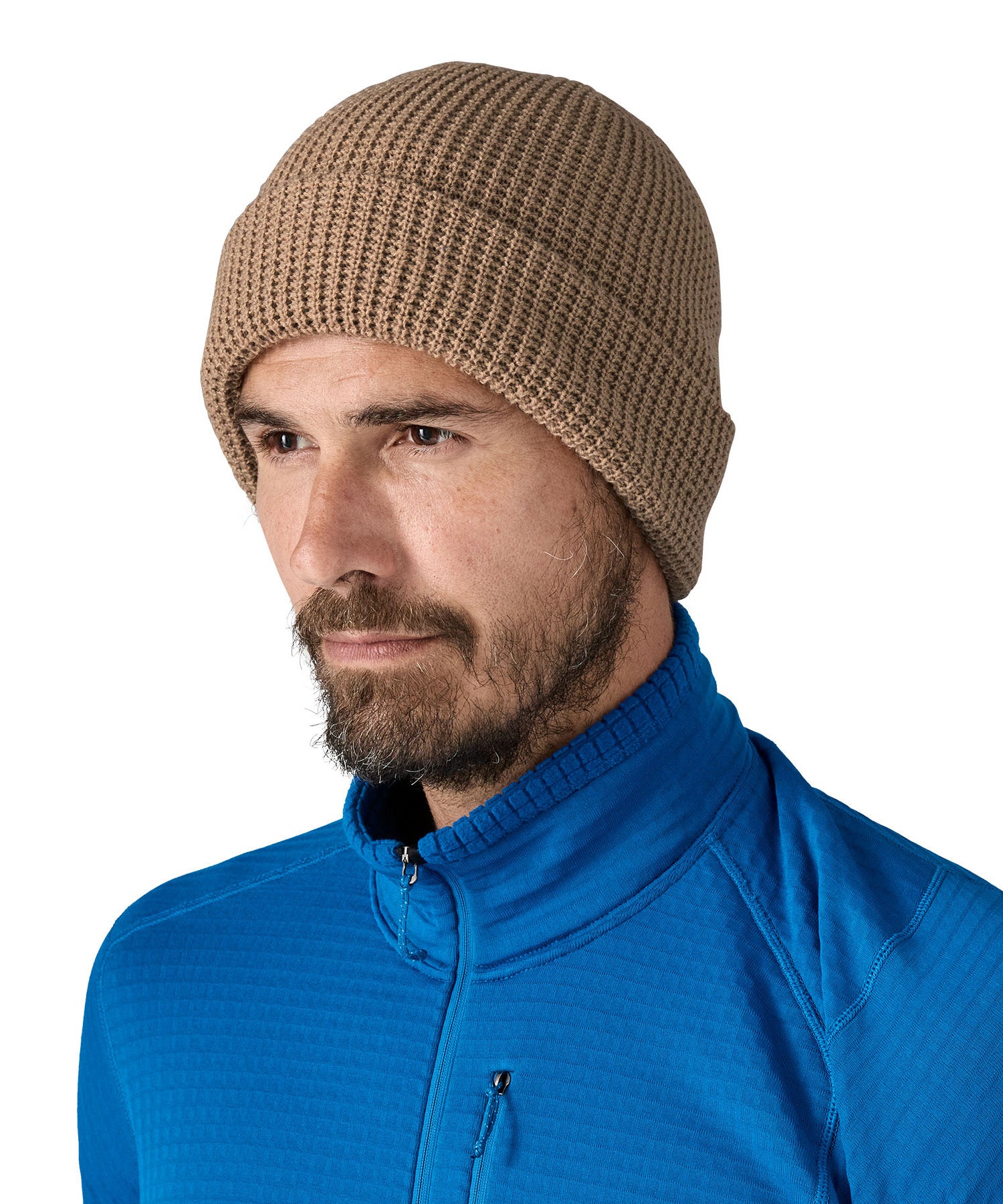 Patagonia adult snow drifter beanie in a pale khaki colour worn by a adult showing the brim turned up.