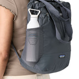 A close up of the smolder blue side mesh pocket on the tote bag for carrying bottles. Showing the straps for easy carrying and front zip detail.
