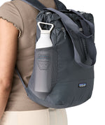 A close up of the smolder blue side mesh pocket on the tote bag for carrying bottles. Showing the straps for easy carrying and front zip detail.