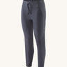 A pair of smolder blue Patagonia running 7/8 tights on a cream background.