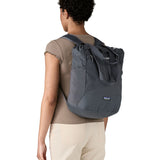 Patagonia Terravia tote bag in smolder blue worn by a adult on the back showing the carrying handle details and side mesh pockets for holding bottles