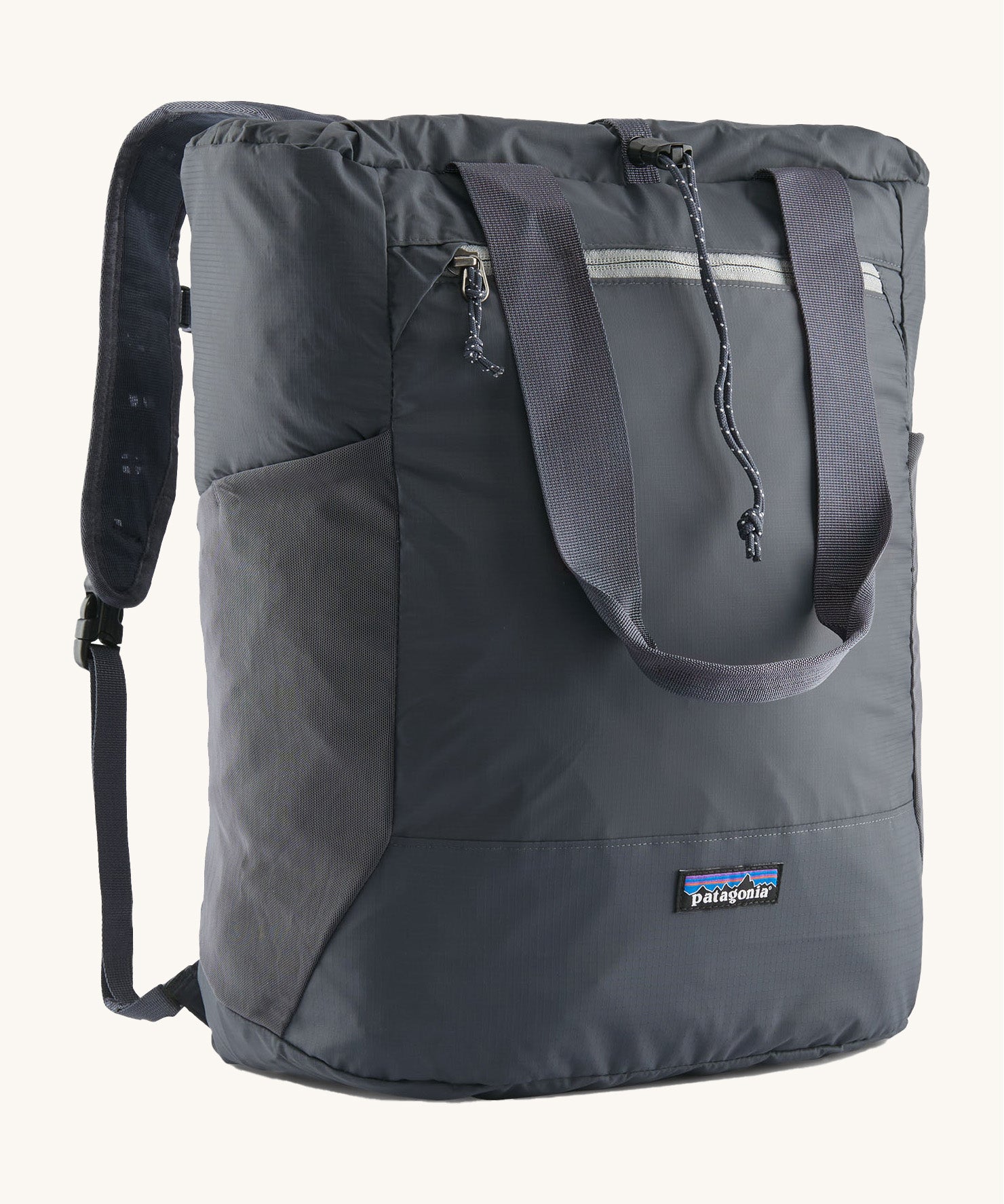 Patagonia Terravia tote bag in smolder blue showing the front zip and strap details with the brand log on the bottom panel. Features shoulder straps for easy carrying.