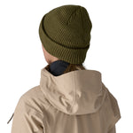 The back of a woman wearing the Patagonia snowdrifter beanie in tent green with rolled up brim available at Babipur.