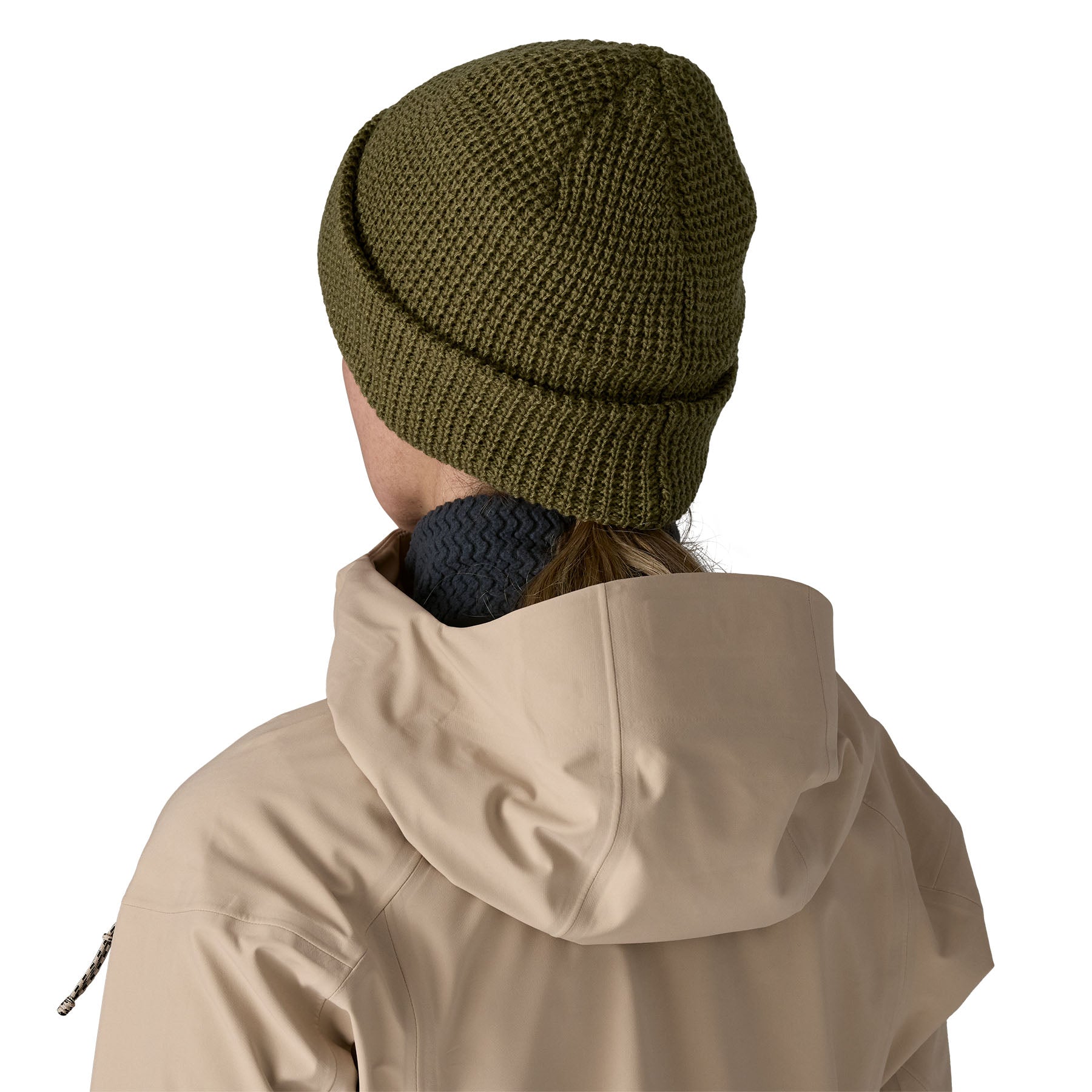 The back of a woman wearing the Patagonia snowdrifter beanie in tent green with rolled up brim available at Babipur.