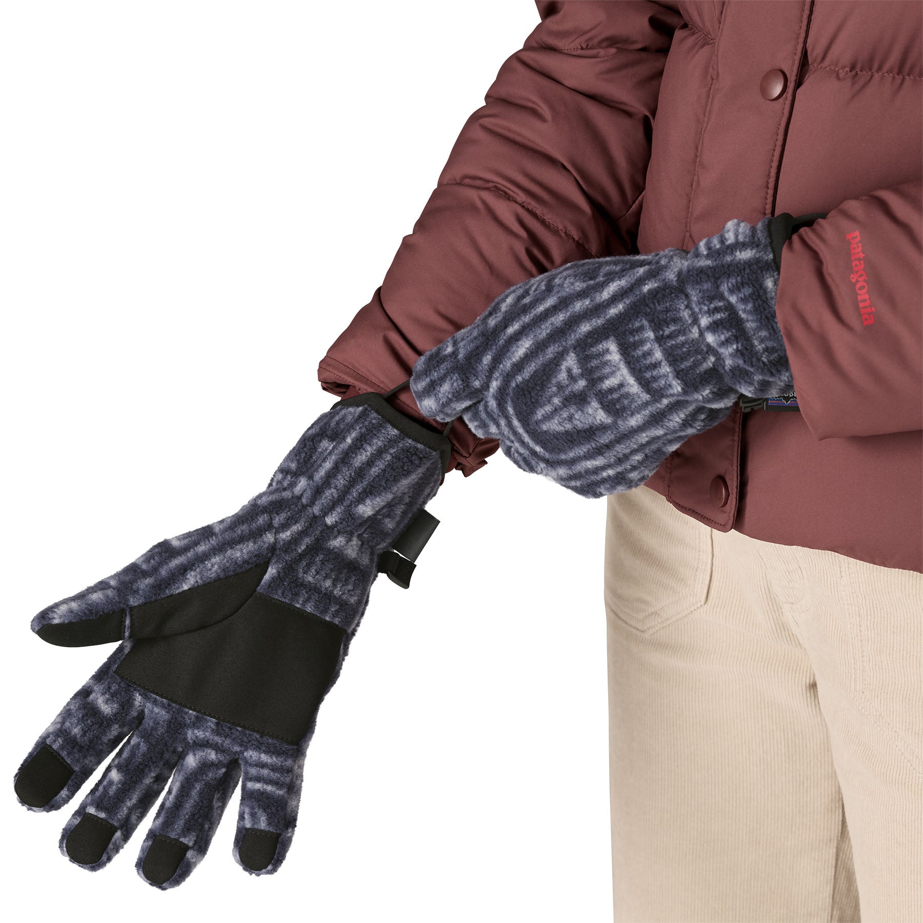 An adult putting on the Patagonia adult synchilla gloves in sunken blue available at Babipur.