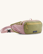 Patagonia terravia hip pack in quiet violet with a green front panel and a small black logo tag on the front. 