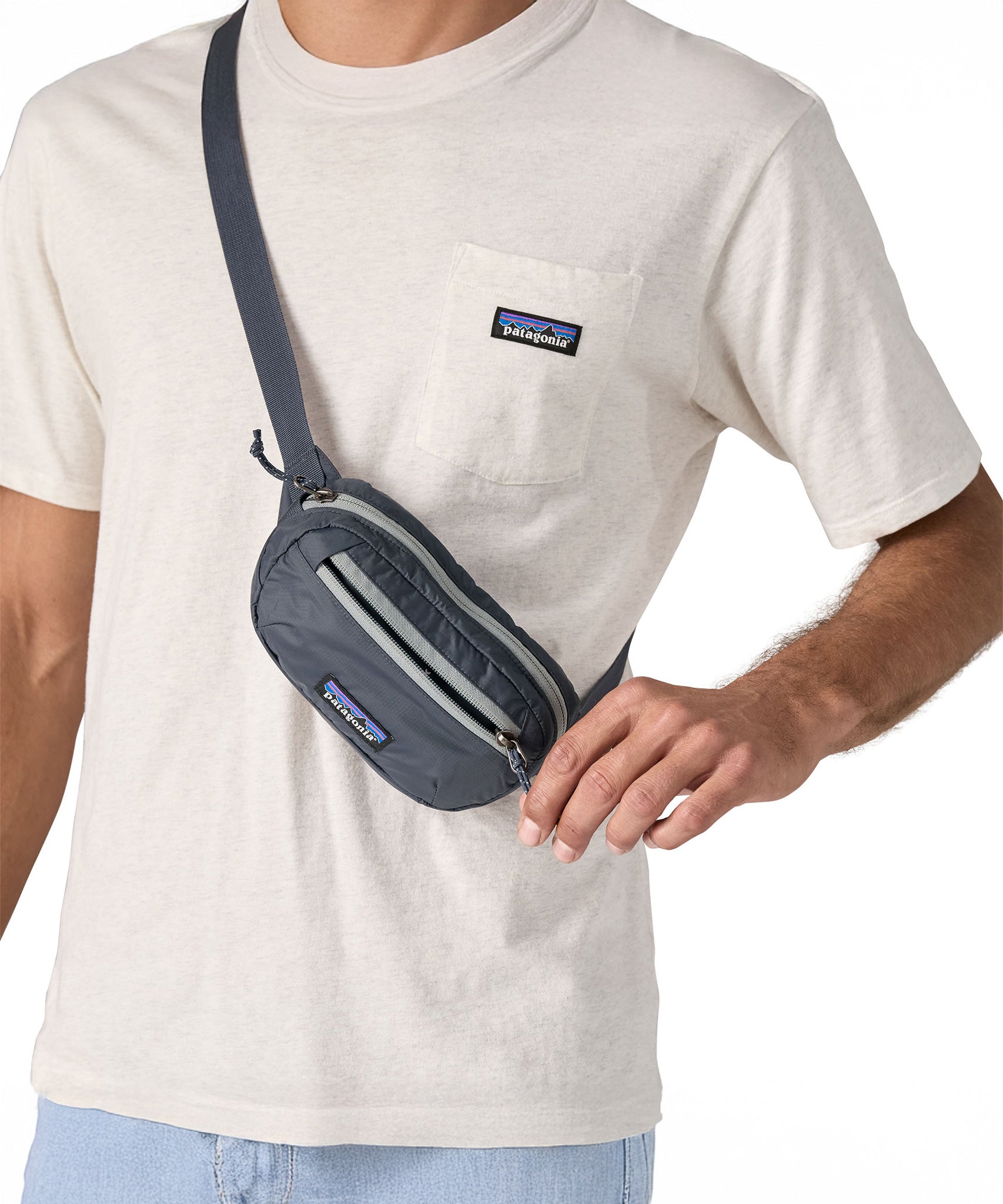 A close up of a man wearing the Patagonia Terravia Mini Bum Bag Hip Pack in a Smolder Blue colour on his shoulder, across his chest. 