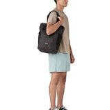 Patagonia Terravia tote bag in black carried by a adult on the shoulder showing the side pockets for holding bottles