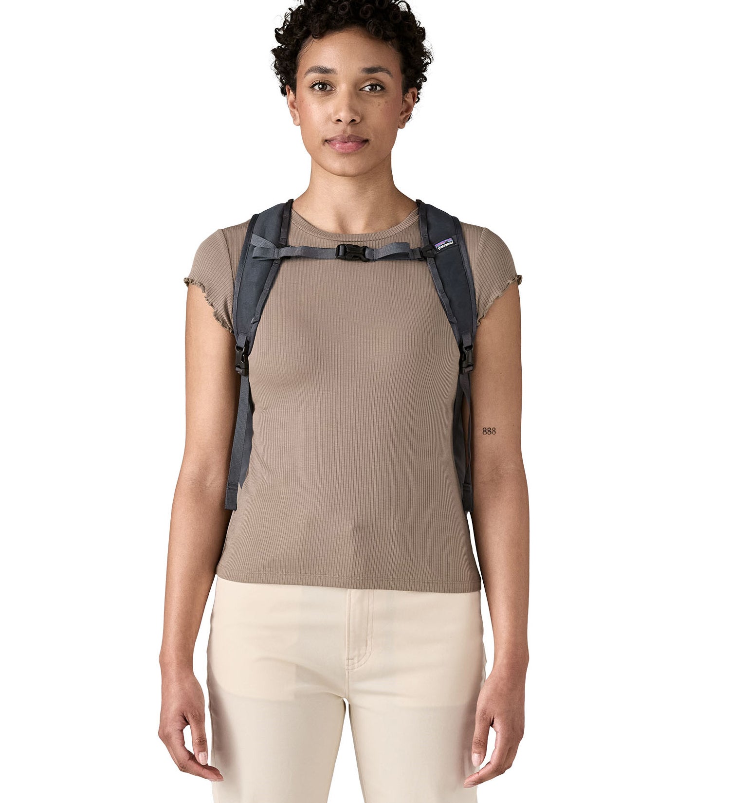Woman wearing Patagonia's Terravia tote bag in blue. Showing quick release buckle on shoulder straps