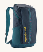 Patagonia 25L black hole backpack in a tidal teal colour on a cream background.