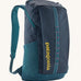 Patagonia 25L black hole backpack in a tidal teal colour on a cream background.