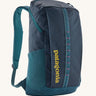 Patagonia 25L black hole backpack in a tidal teal colour on a cream background.