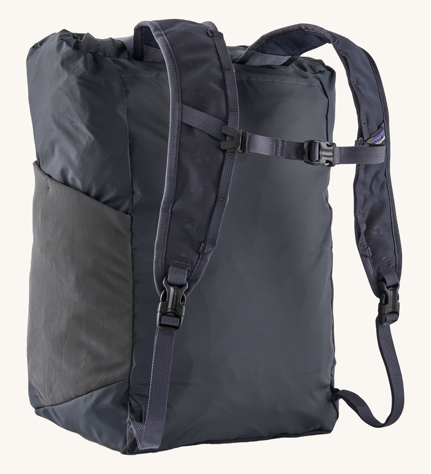 Back view of the Patagonia Terravia tote bag in smolder blue colour showing the blue strap detail with buckle for fastening. Features side mesh pockets for holding bottles.