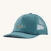 Patagonia broadcaster cap in turquoise colour on a cream background.
