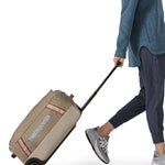 Patagonia 40L wheeled duffel bag being wheeled by a adult
