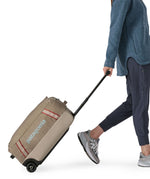 Patagonia 40L wheeled duffel bag being wheeled by a adult