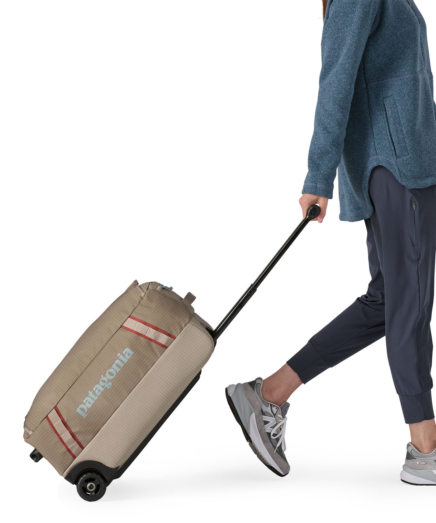 Patagonia 40L wheeled duffel bag being wheeled by a adult