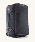 Patagonia 40L black hole wheeled duffel bag on a cream background.