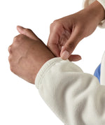 Woman pulling on the elasticated cuff Patagonia's women's microdini fleece jacket in white 