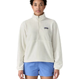 Woman wearing Patagonia women's microdini fleece in white showing half length front zip fastened