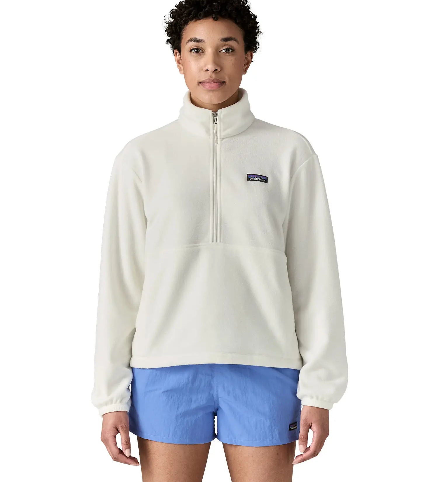 Woman wearing Patagonia women's microdini fleece in white showing half length front zip fastened