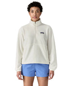 Woman wearing Patagonia women's microdini fleece in white showing half length front zip fastened