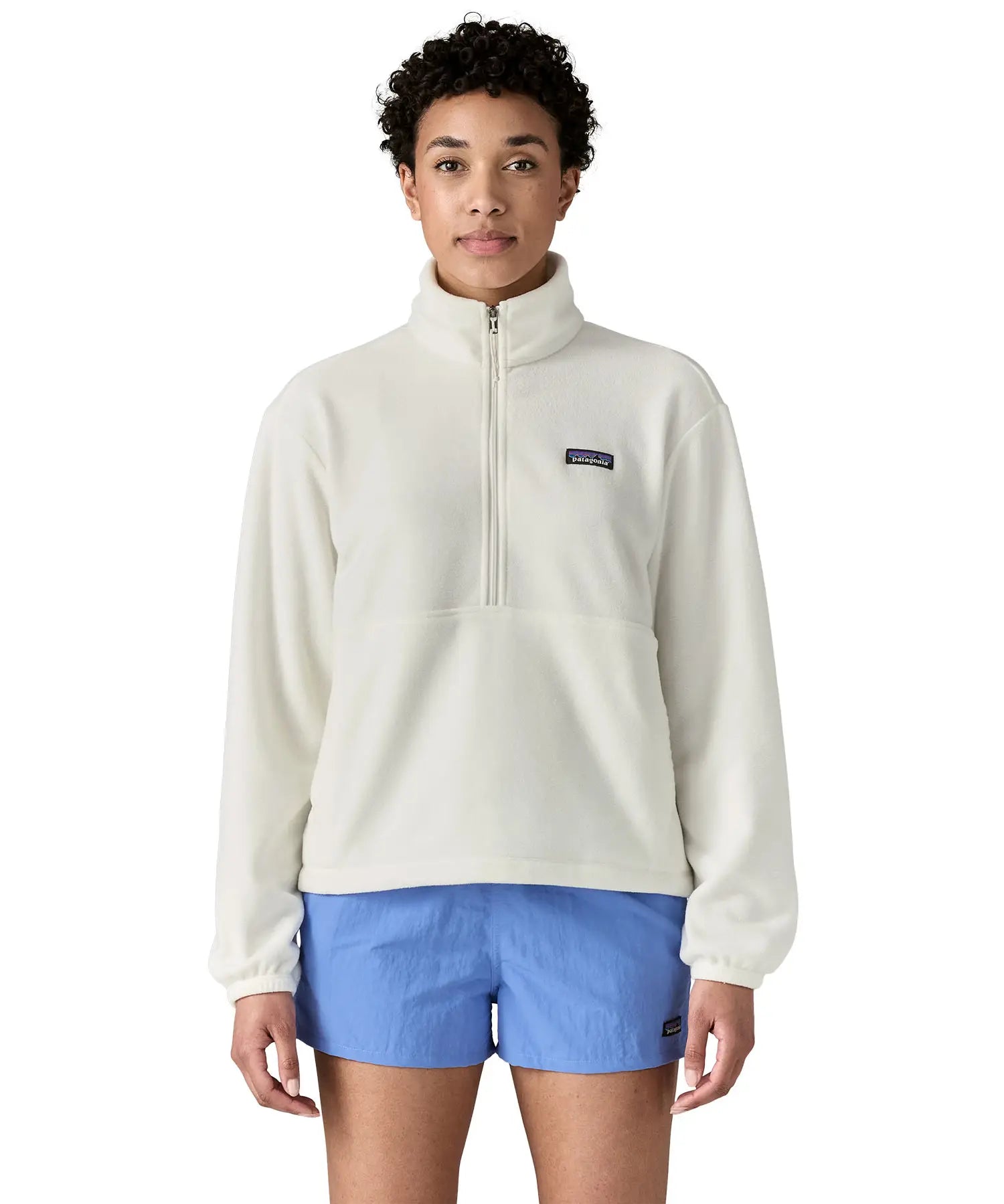 Woman wearing Patagonia women's microdini fleece in white showing half length front zip fastened