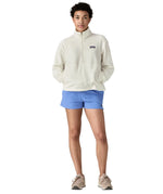 Front of woman wearing Patagonia women's microdini fleece  in white. Fleece has a relaxed fit and sits at the hips