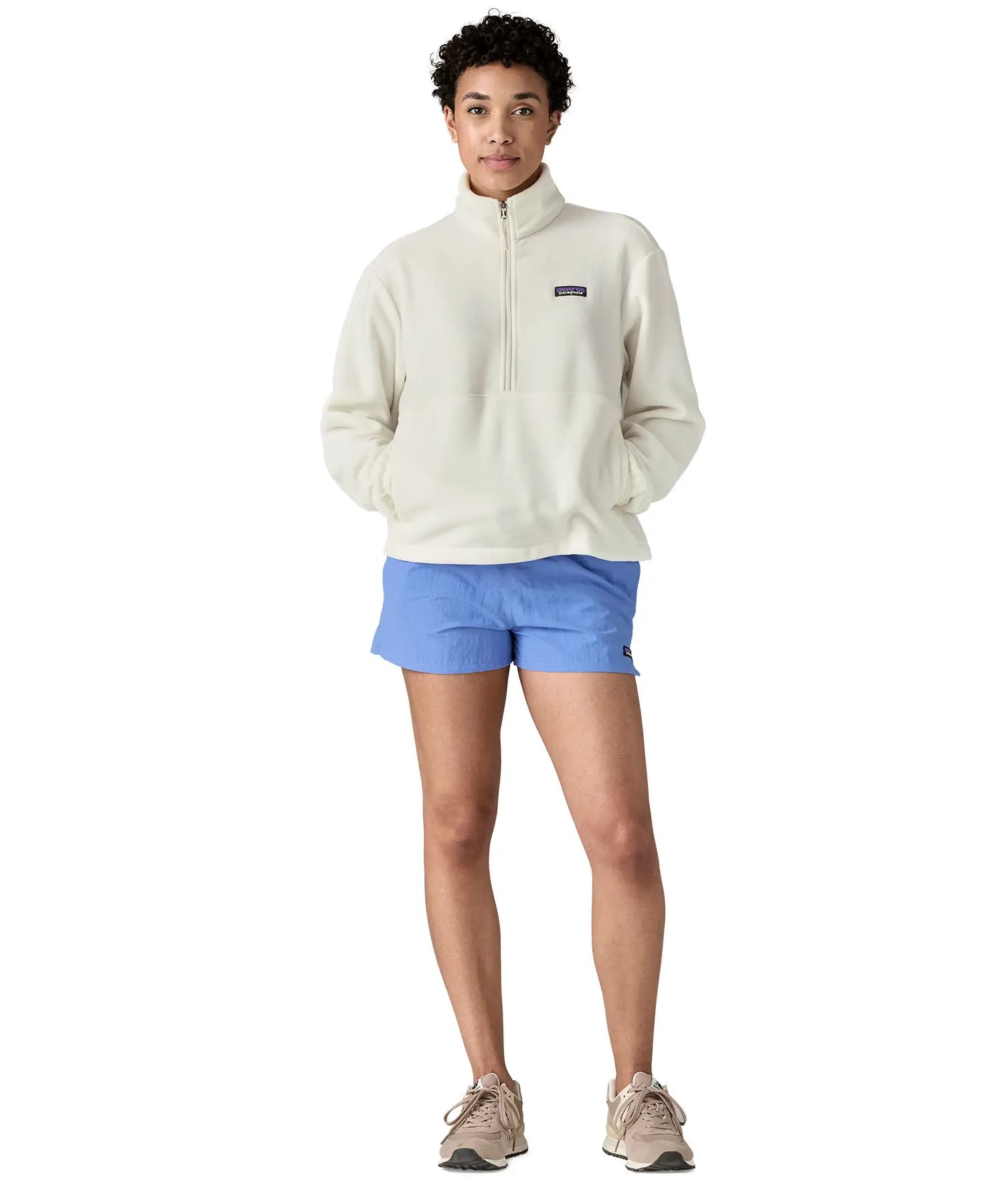 Front of woman wearing Patagonia women's microdini fleece  in white. Fleece has a relaxed fit and sits at the hips