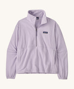 Patagonia women's micro 1/2 zip fleece in a light purple colour on a cream background.