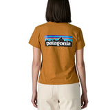 Woman wearing the Patagonia women's P-6 logo responsibili-tee short sleeved t-shirt in dried mango yellow showing the large logo on the back. 